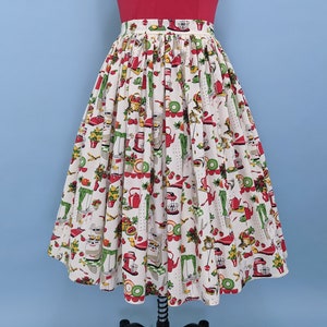 May include: A white full skirt with a red, green and yellow print of kitchen appliances and food. The skirt has a gathered waist and a full, flowing silhouette.