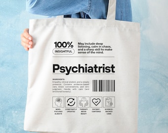 May include: A white tote bag with the word "Psychiatrist" in bold black letters. The bag features text describing the qualities of a psychiatrist, including "insightful" and "empathy." The bag also has icons representing key concepts.