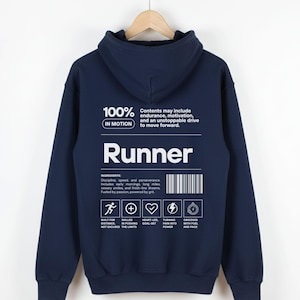 May include: Navy blue hoodie with the word "Runner" in white block letters. The back of the hoodie features text that reads "100% in motion" and a list of ingredients for running, including discipline, speed, and perseverance. A barcode is also present.