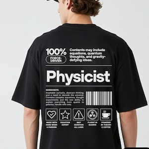 Op de afbeelding: Een zwart t-shirt met witte grafische tekst op de achterkant. Het ontwerp bevat het woord Physicist, een streepjescode en iconen die hard werken, vergelijkingsexpertise, het bevragen van wetten, kwark-vloeiendheid en koffie voorstellen.