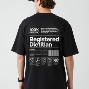 Pu&ograve; includere: T-shirt nera con testo bianco "Registered Dietitian". Il retro della maglietta presenta anche le parole "100% Dedicated" e un elenco di "Ingredienti" tra cui conoscenze basate sull'evidenza e saggezza nel controllo delle porzioni.