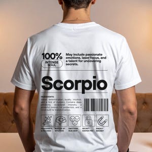 Pode incluir: Camiseta branca com design gr&aacute;fico preto com a palavra "Scorpio" e texto relacionado. A camiseta inclui um c&oacute;digo de barras e &iacute;cones que representam tra&ccedil;os-chave. O design est&aacute; centrado nas costas.