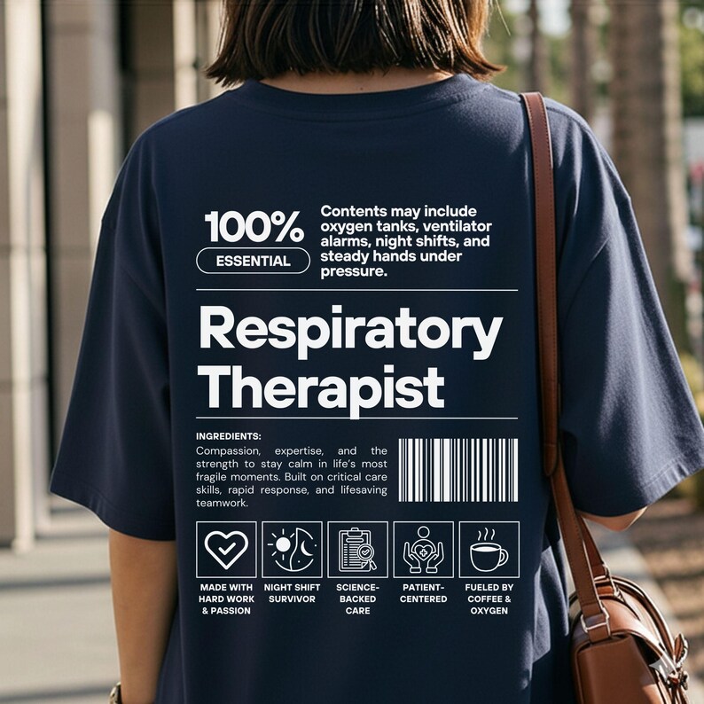 Może przedstawiać: Granatowa koszulka z białym napisem "Respiratory Therapist". Koszulka zawiera listę składnik&oacute;w i ikony. Tekst na koszulce brzmi "100% Essential" i "Contents may include oxygen tanks, ventilator alarms, night shifts, and steady hands under pressure."