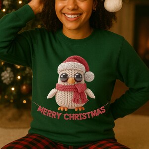 May include: A dark green sweatshirt with a knitted owl design, complete with a red scarf and Santa hat. The words "Merry Christmas" are embroidered in pink. This festive sweatshirt is perfect for the Christmas season.