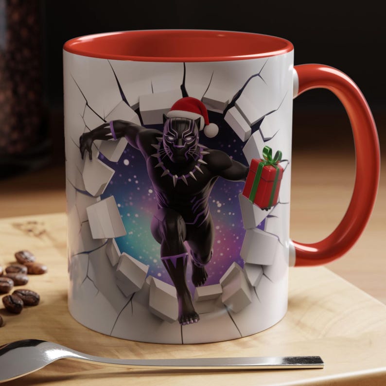 Peut inclure: Mug en c&eacute;ramique blanche avec int&eacute;rieur et anse rouges. Le mug pr&eacute;sente un graphisme de Black Panther portant un bonnet de P&egrave;re No&euml;l, per&ccedil;ant un mur et tenant un cadeau. L'arri&egrave;re-plan est une galaxie color&eacute;e.