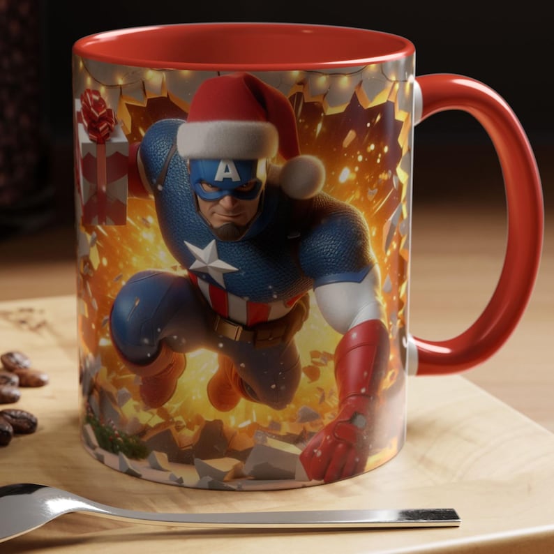 Peut inclure: Une tasse &agrave; caf&eacute; avec une poign&eacute;e rouge repr&eacute;sentant Captain America portant un bonnet de P&egrave;re No&euml;l. Le design de la tasse comprend un fond festif et un int&eacute;rieur rouge. La tasse est sur une surface en bois.