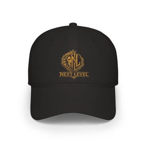Peut inclure: Casquette de baseball noire avec une tête de lion dorée et les lettres "NL" dans un écusson. Le texte "NEXT LEVEL" est en dessous. La casquette a une visière incurvée et une couronne structurée.