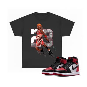 May include: A white ceramic mug with a black handle and the text "But First, Coffee" in a bold, black font. The mug is set against a blurred background, highlighting its clean design.