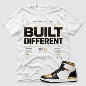 May include: A white short-sleeve t-shirt featuring the black text BUILT DIFFERENT, the phrase ENGINEERED TO STAND OUT, and technical grid graphics. Below the text is EST. 23 and BLACK / WHITE / GOLD. A high-top sneaker in black, white, and gold is included.