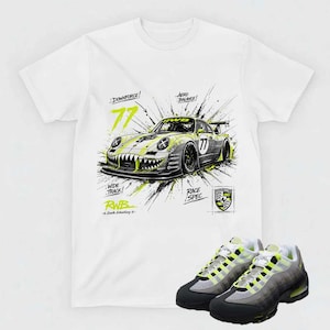 May include: White t-shirt with a graphic of a race car with the number 77 and the words "Downforce!", "Wide Track!", "Aero Balance!", and "Race Spec". The shirt is paired with gray and black sneakers with neon green accents.