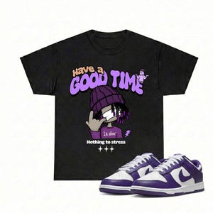 May include: Black t-shirt with a purple graphic that says "Have a Good Time" and a cartoon character. The image also shows a pair of purple and white sneakers.