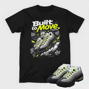 May include: Black t-shirt with a graphic of sneakers and the text "Built to Move." The design includes the phrases "Keep Going!" "Game On!" and "Fast Life." A pair of matching sneakers are displayed below the shirt.