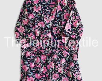 May include: Black floral pajama set with pink flowers and green leaves. The set includes a button-down top and shorts, both trimmed with white piping. The text "The Jaipur Textile" is visible at the bottom of the image.