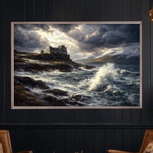 Puede incluir: Una impresión enmarcada de una dramática escena costera. Un castillo de piedra se alza sobre un acantilado rocoso, con olas rompiendo y un cielo tormentoso. La obra de arte presenta tonos de gris, azul y blanco, creando un paisaje melancólico y atmosférico.