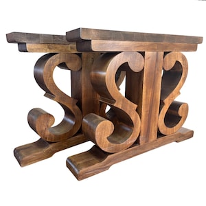 Könnte beinhalten: Zwei Tischbeine aus Holz mit dunkelbraunem Finish. Die Beine weisen ein dekoratives Scroll-Design und eine rechteckige Oberseite auf. Die Beine sind aus massivem Holz gefertigt und eignen sich für einen rustikalen oder Landhausstil.