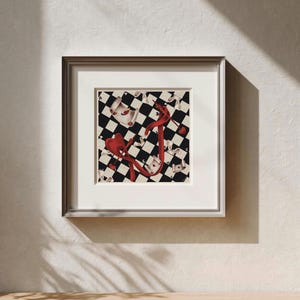 Può includere: Opera d'arte incorniciata con un motivo di carte da gioco. L'immagine ha uno sfondo a scacchi in bianco e nero con nastri e cuori rossi. La cornice argentata circonda l'opera d'arte, esposta su una parete bianca.