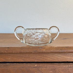 May include: A set of three ceramic mugs with a speckled, matte finish. The mugs are in shades of cream, light gray, and dark gray. Each mug has a simple, modern design and a rounded handle. The mugs are stacked on top of each other.