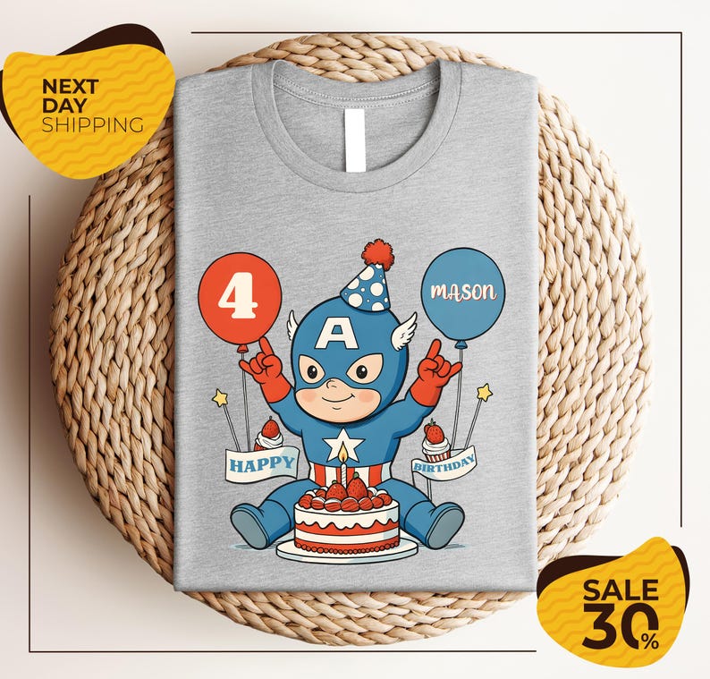 A gray t-shirt with a cartoon image of a superhero character wearing a party hat and holding balloons, celebrating a birthday.