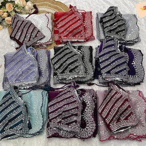 Puede incluir: Conjunto de blusas de mujer y conjuntos de tela a juego, con intrincados bordados y lentejuelas. Los colores incluyen rojo, negro, morado y verde azulado. Los conjuntos están cuidadosamente dispuestos.