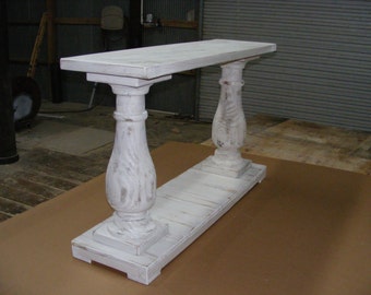 May include: White painted wooden console table with a rectangular top and two turned legs. The table has a distressed finish and is supported by a base with a shelf.