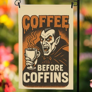 Peut inclure: Un drapeau de jardin avec une illustration vintage d'un vampire tenant une tasse de café. Le texte dit "COFFEE BEFORE COFFINS" en orange et marron. Le vampire a des crocs et porte une cape noire.