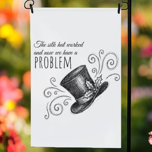 May include: White garden flag featuring a black and white drawing of a top hat and decorative swirls. The text reads "The silk hat worked and now we have a PROBLEM."
