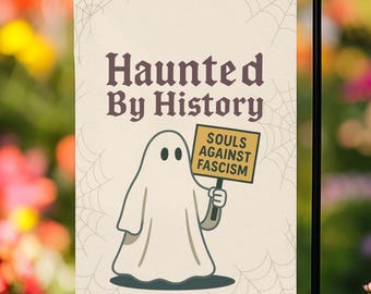 May include: A garden flag featuring the words "Haunted By History" in dark brown. A cartoon ghost holds a sign saying "Souls Against Fascism." The background is off-white with a spiderweb design.