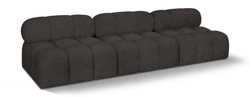 K&ouml;nnte beinhalten: Ein dunkelbraunes Dreisitzer-Sofa mit getuftetem Design. Das Sofa hat ein niedriges Profil und eine abgerundete R&uuml;ckenlehne. Die Kissen sind quadratisch und gleichm&auml;&szlig;ig verteilt. Das Sofa ist aus einem strukturierten Stoff gefertigt.