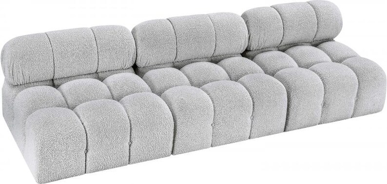 K&ouml;nnte beinhalten: Ein hellgraues, modulares Sofa mit einem abgerundeten, strukturierten Design. Das Sofa verf&uuml;gt &uuml;ber eine Reihe einzelner, gepolsterter Abschnitte, die ein einzigartiges, wolkenartiges Aussehen erzeugen. Die R&uuml;ckenlehne besteht aus drei rechteckigen Abschnitten, und der Sitz hat mehrere abgerundete Abschnitte.