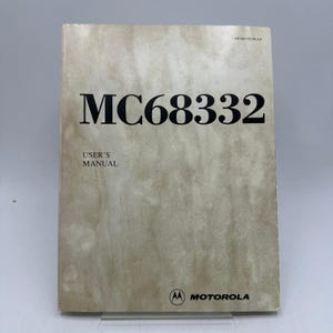 May include: A vintage user's manual for the MC68332, with the Motorola logo at the bottom. The cover is a light tan color with the title in large, bold, black letters. The text "USER'S MANUAL" is below the title.