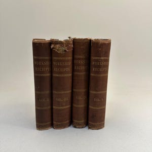 May include: Four antique books with brown covers are displayed. The spines read "WORKSHOP RECEIPTS" with volume numbers. The books are arranged side by side, with some wear visible on the covers.