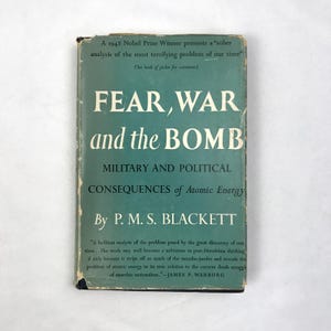 May include: A vintage book titled "FEAR, WAR and the BOMB" by P.M.S. Blackett. The cover is teal with white text, including the subtitle "MILITARY AND POLITICAL CONSEQUENCES of Atomic Energy." The book is a 1948 Nobel Prize Winner's analysis.