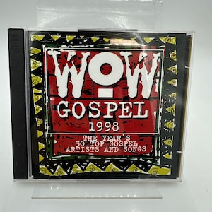 Op de afbeelding: Een cd-hoesje met het album "WOW Gospel 1998". De hoes heeft een rood en zwart ontwerp met de titel in grote witte letters. De tekst "The Year's 30 Top Gospel Artists and Songs" is ook zichtbaar.