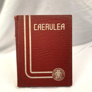 May include: A vintage, red hardcover book with the word "CAERULEA" in white block letters. The book has a white vertical stripe design and a Long Beach Polytechnic High School emblem.
