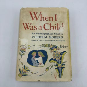 May include: Vintage book titled "When I Was a Child" by Vilhelm Moberg. The cover is aged with a cream background and red text. It features an illustration of two figures in a blue oval and floral designs.