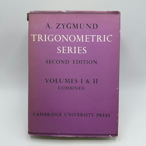 Może przedstawiać: Zabytkowa książka zatytułowana "Trigonometric Series" autorstwa A. Zygmunda. Okładka jest w kolorze głębokiego fioletu z białym tekstem. Książka jest połączonym wydaniem tomów I i II, wydanym przez Cambridge University Press.