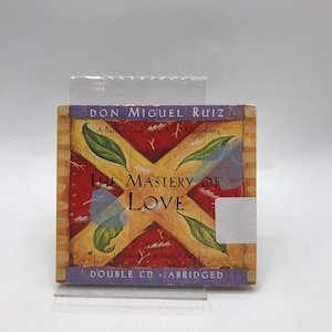 May include: A double CD of "The Mastery of Love" by Don Miguel Ruiz. The cover features a red and yellow design with green leaves and the book title in large, bold letters. The text "A Practical Guide to the Art of Relationships" is also visible.