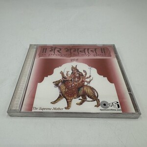 May include: A CD case featuring a maroon and white cover with the text "a prayer to my god" and "The Supreme Mother." The cover art depicts a deity riding a tiger. The CD case is in a clear plastic case.