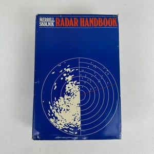 May include: A blue book titled "Radar Handbook" by Merrill Skolnik. The cover features a radar screen graphic in white and a red line. The book is rectangular and appears to be in good condition.