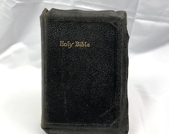 May include: A black leather-bound Holy Bible with gold lettering.