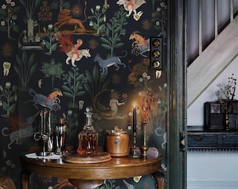 May include: Dark wallpaper with a repeating pattern of mythical beasts and foliage. A wooden table holds a decanter, cocktail shaker, and other bar accessories. A lit candle and a vintage light switch are also visible.