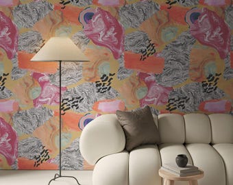 May include: A living room scene featuring a cream-colored sofa, a small wooden side table, and a floor lamp. The wall is adorned with colorful abstract wallpaper in shades of orange, pink, and gray. A brown pillow rests on the sofa.