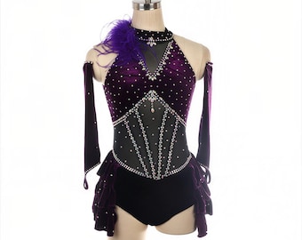 May include: A purple velvet dance costume with a halter neckline and black bodice. The costume features rhinestone embellishments, a sheer mesh panel, and a ruffled skirt. A purple feather detail adorns the shoulder. The costume is displayed on a mannequin.