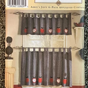 May include: Simplicity Home sewing pattern 8695 for Abbie's Jiffy 6-Pack Appliqued Curtains. The package features a black and white gingham curtain set with red apple appliques, displayed on two rods with decorative metal finials.
