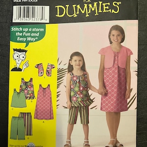 May include: Simplicity sewing pattern for girls' clothing, sizes 3, 4, 5, and 6. The pattern includes options for dresses, tops, and shorts. The cover features illustrations of the finished garments and the text "Sewing Patterns for Dummies".