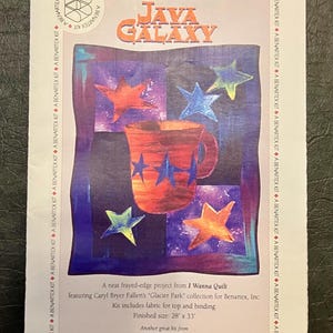 May include: A Benartex Java Galaxy quilt kit. The image features a colorful design with a coffee mug and stars. The finished size is 28 x 33 inches.
