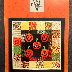 May include: A craft pattern titled "Five Little Pumpkins" features a quilt design with five orange jack-o'-lanterns on a black background. The pattern includes various fabric squares in orange, yellow, and green, set against an orange background.