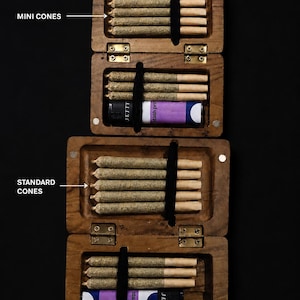 May include: Two rectangular wooden cases with metal hinges, each containing pre-rolled cones and a lighter. The top case is labelled MINI CONES and holds smaller cones, while the bottom case is labelled STANDARD CONES and holds larger cones.