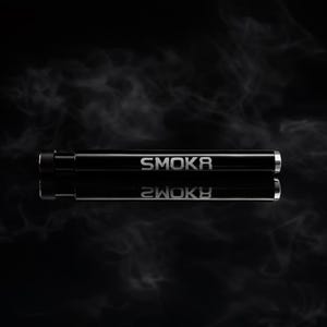 Puede incluir: Un dispositivo cilíndrico negro con la palabra "SMOKR" en letras plateadas. El dispositivo se refleja en una superficie oscura, creando un efecto de espejo. El fondo es un degradado oscuro con volutas de humo.