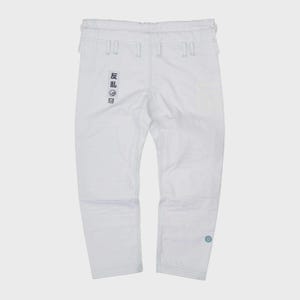 May include: White martial arts pants with visible stitching and a drawstring waist. The pants feature a small patch with Japanese text on the left leg and a circular emblem on the right leg. The pants are made of a durable material.